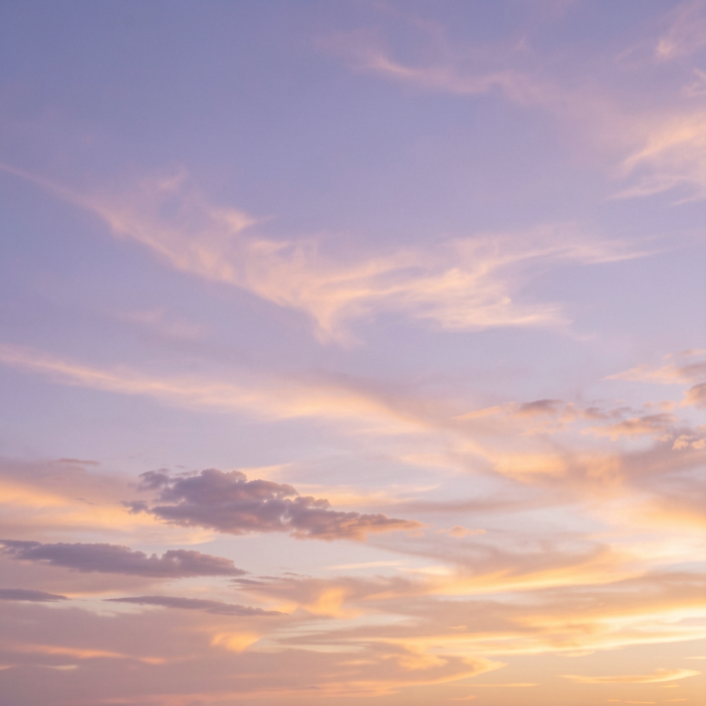 Cielo despejado con nubes suaves iluminadas por un atardecer en tonos lavanda y dorado, textura simbólica del elemento aire